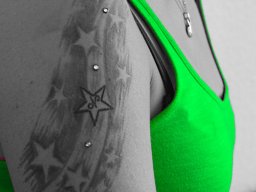 4 Dermal Anchor in einem Tattoo eingesetzt am Oberarm mit Sternen nach kompletter Abheilung